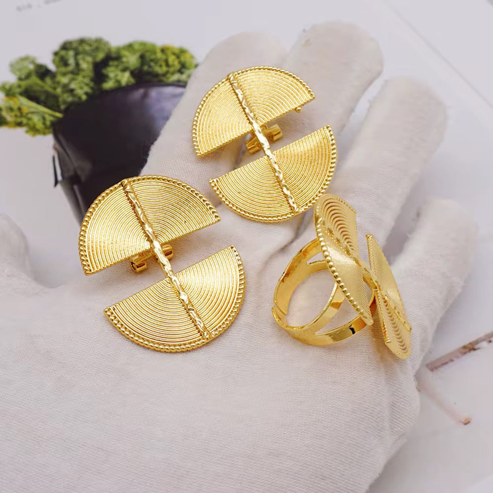 Baule Gold jewelry set including earrings and a ring on a white surface